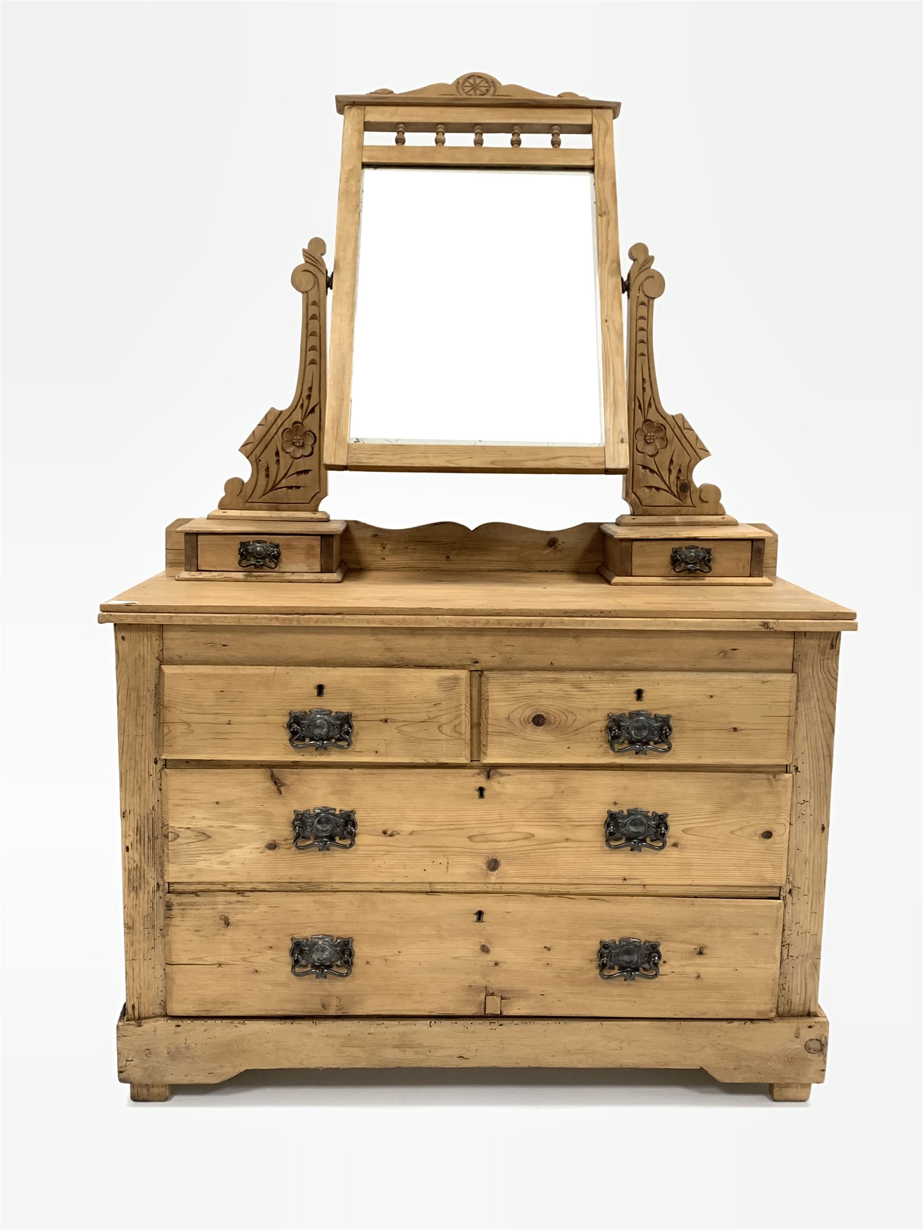 Edwardian pine dressing chest, the bevelled swing mirror raised on two floral carved uprights over t