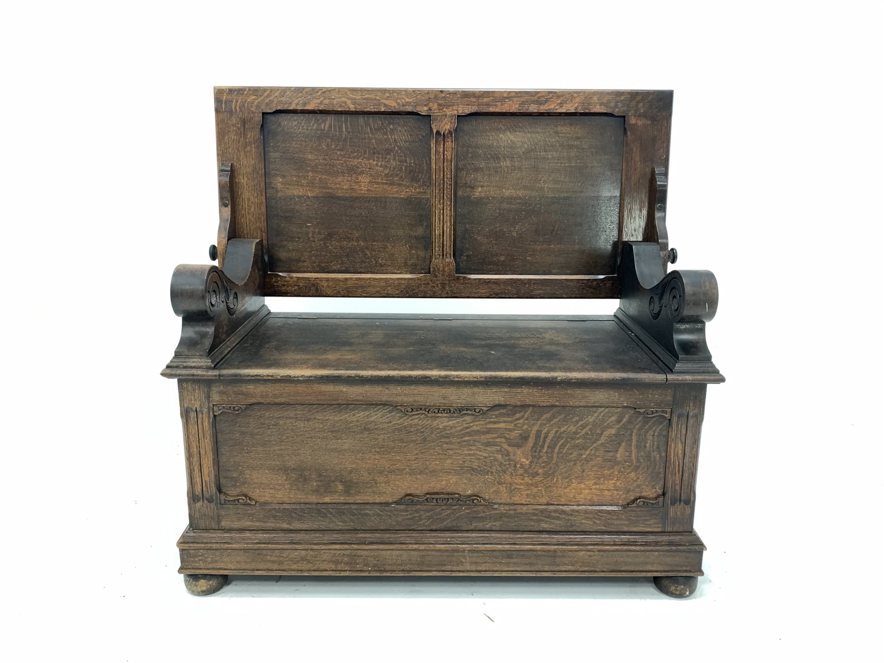 Early 20th century oak monks bench, the folding panelled back rest over hinged seat, panelled front