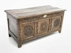 18th century and later three panel oak coffer, with floral carved roundels, raised on stile supports