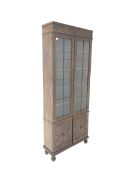 Early 20th century oak bookcase on cupboard, frieze with applied roundel over two glazed doors enclo