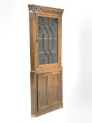 Early 19th century oak floor standing corner cupboard, projecting cornice over astragal glazed door