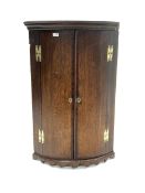 18th century George III oak bow front wall hanging corner cupboard, projecting cornice over two maho