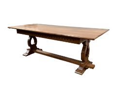 Large oak dining table, incised carved frieze, shaped and pierced supports with sledge feet, united