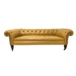 Victorian low back Chesterfield sofa, upholstered in button leather, raised on turned walnut support