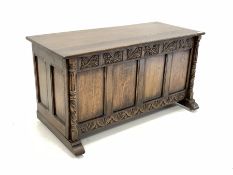 20th century medium oak blanket box with hinged top over floral carved frieze, four panel front and