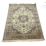 Persian design silk ground rug, central medallion on busy ivory field with blue spandrels, enclosed