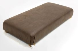 Large contemporary rectangular footstool, upholstered in brown leather, raised on compressed bun sup