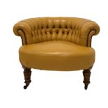 Victorian tub shaped chair upholstered in deep buttoned and studded leather, raised on turned walnut