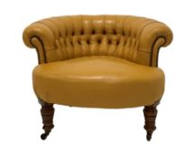 Victorian tub shaped chair upholstered in deep buttoned and studded leather, raised on turned walnut