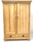 20th century stripped pine double wardrobe, projecting cornice over two panelled doors enclosing int