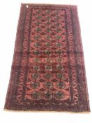 Persian Bokhara red ground rug, gul motif on red field enclosed by multi line border