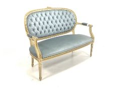 Louis XV style cream and gilt painted two seat sofa, with scrolled open arms, upholstered in buttone