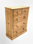 Traditional polished pine chest, fitted with two short and three long drawers, raised on skirted bas