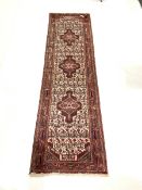 Iranian red ground runner, triple medallion on pale field decorated with repeating motifs