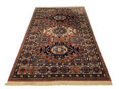 Persian Kadjar design ground rug, repeating lozenge and gul motif on red field, stylised floral deco