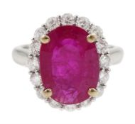 White gold oval ruby and round brilliant cut diamond cluster ring