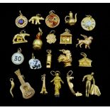 Twenty one 18ct gold charms including guitar