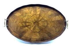 Edwardian walnut oval two handled tray composed of radiating veneers within a raised border L65cm