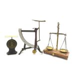 Set of brass balance scales and five weights on wooden base