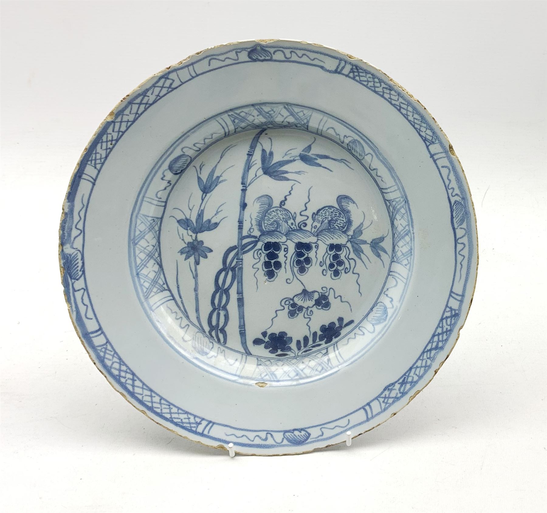 18th century Delft tin-glazed plate decorated with Squirrels feeding on fruiting vine amidst bamboo