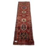 Persian karajeh red ground runner rug with repeating geometric medallions 70cm x 256cm