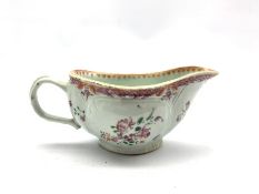 18th century porcelain sauceboat hand-painted with floral sprays beneath a pink scale border