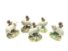 Two pairs of 19th century Staffordshire spill vases modelled as sheep before tree trunks