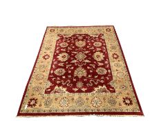 Knotted wool red ground rug with floral design 314cm x 243cm