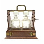 Oak two bottle tantalus with two square cut spirit decanters and traces of original silver plate H30