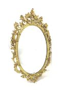 Ornate gilt framed oval wall mirror with floral scrolled decoration 57cm x 97cm