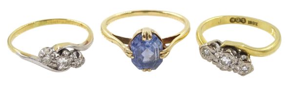Two early 20th century 18ct gold three stone diamond rings and a 15ct gold single blue stone ring
