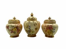 Pair of Royal Worcester pot pourris and covers decorated with floral sprays on a blush ivory ground