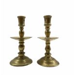A matching pair of brass Heemskerk type candlesticks with mid drip trays
