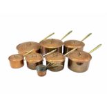 Set of seven graduated Italian copper saucepans and covers with brass handles