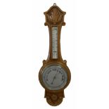 An English 1930�s solid oak carved hall barometer in a scroll shaped carved case with applied floral