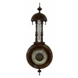 An Edwardian carved pendant framed hall barometer with a compensated Aneroid movement by the German
