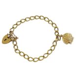 Gold curb link bracelet with heart locket clasp and a shell charm