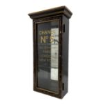 Ebonised display case with glazed door and later stencilled lettering 'Chanel No 5' 61cm x 30cm