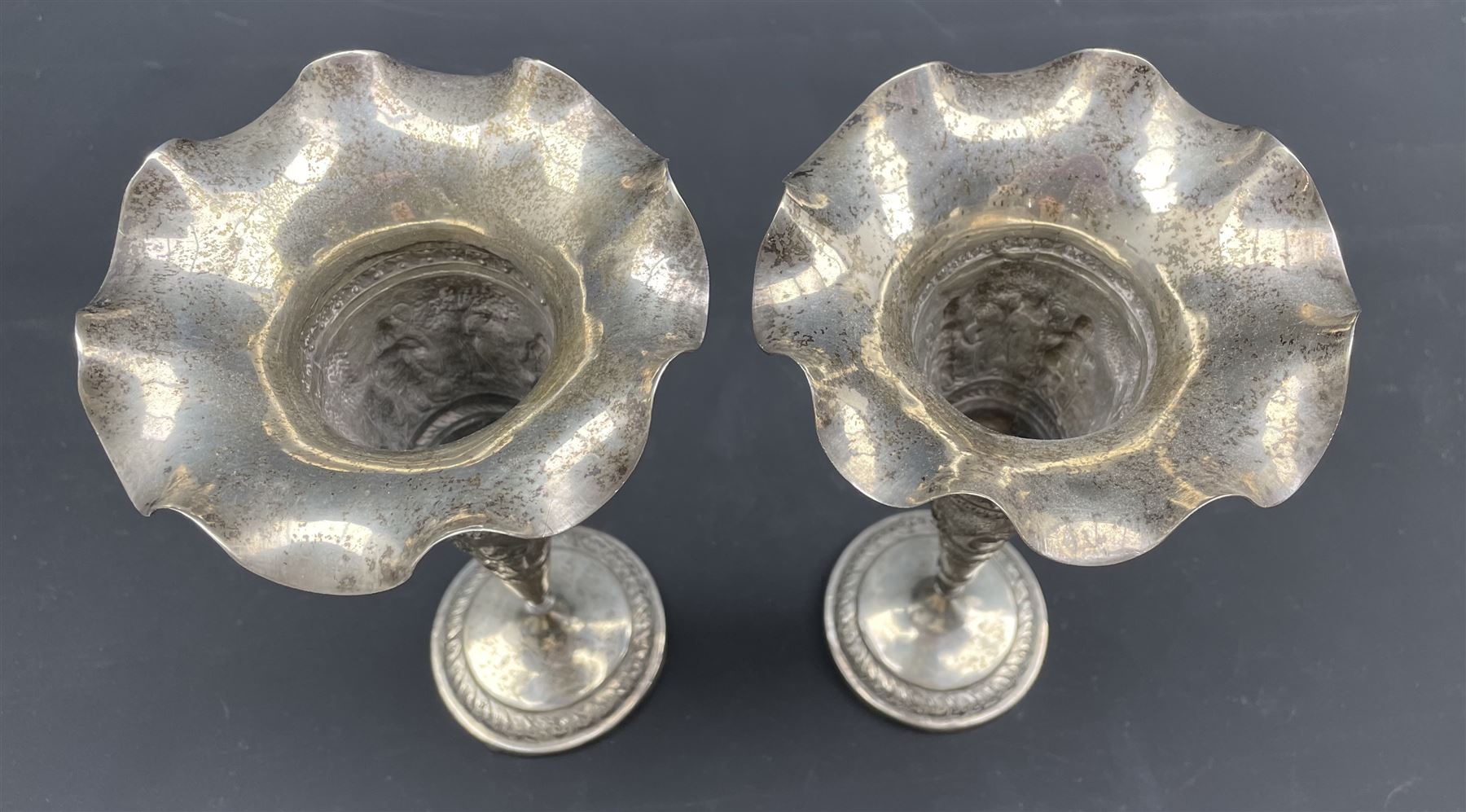 Pair of Indian White Metal trumpet shape vases with embossed decoration of figures and landscapes ma - Image 3 of 3