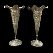 Pair of Indian White Metal trumpet shape vases with embossed decoration of figures and landscapes ma