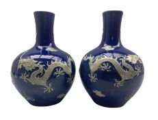 Pair of Yuan style Chinese blue glazed bottle shaped vases each decorated in high relief with dragon