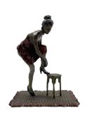 A cold painted bronze of a lady with her foot on a stool