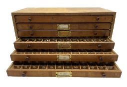 A six drawer printers chest containing a quantity of metal stamps/ matrices and other accessories