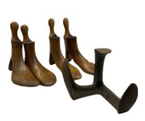 Four early 20th century beech shoe stretchers by Dowie & Marshall and a Cobbler's cast iron last