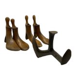 Four early 20th century beech shoe stretchers by Dowie & Marshall and a Cobbler's cast iron last