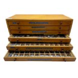 A six drawer printers chest containing a quantity of metal stamps/ matrices and other accessories