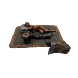 A cold painted bronze of a reclining nude lady on a rug in the manner of Bergman
