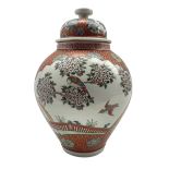 Japanese vase and cover decorated with panels of exotic birds in a fenced garden setting