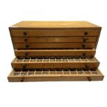 A six drawer printers chest containing a quantity of metal stamps/ matrices
