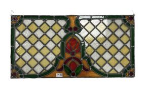 Early 20th century stained and leaded glass panel with lozenges and stylised floral decoration 75cm
